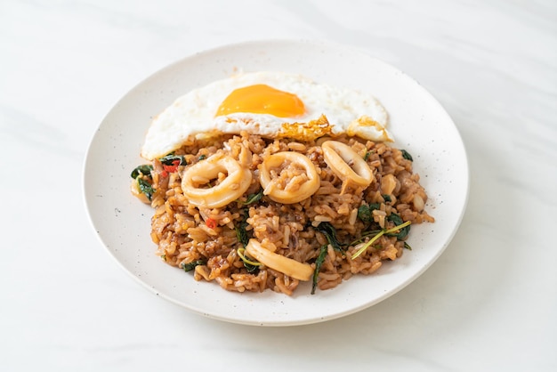 Fried rice with squid and basil topped fried egg in Thai style