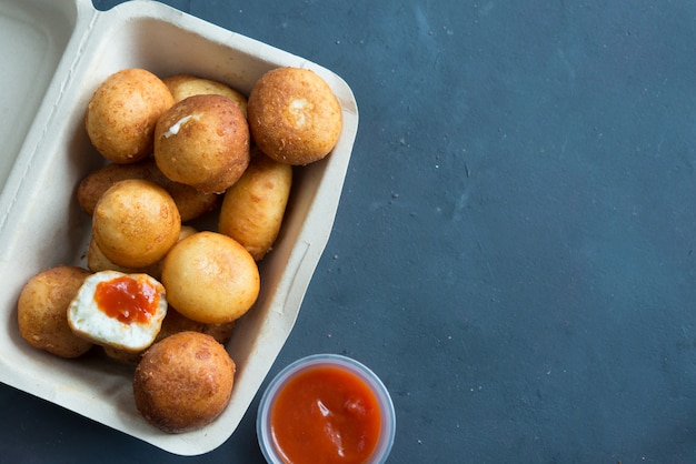 Fried Risotto Arancini stuffed with cheese, served with tomato sauce