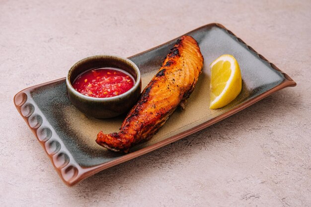 Fried salmon steak with lemon on plate