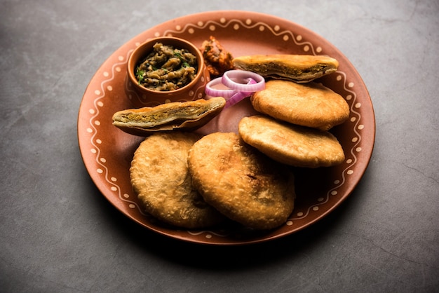 Fried Sattu Litti chokha served with Baingan Bharta, onion and pickle, popular recipe from Bihar, India