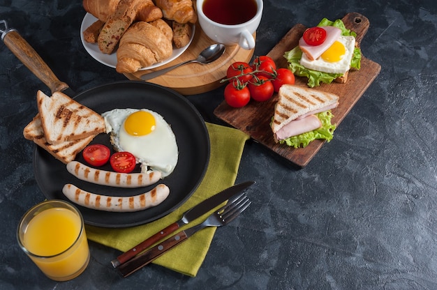 Fried sausage with eggs and vegetables on pan