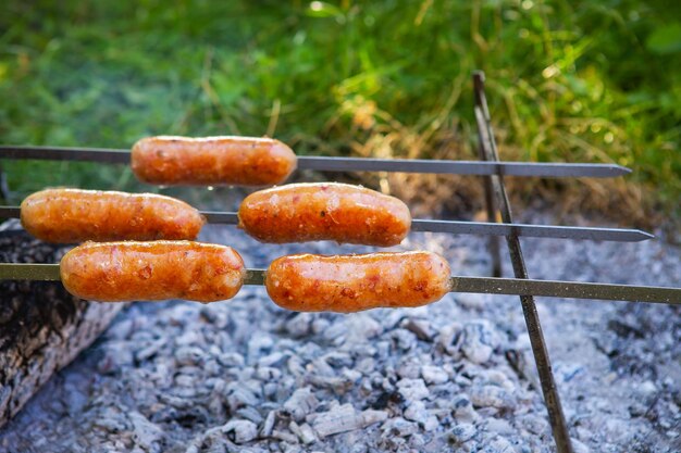 Fried sausages on skewers Summer evenings near the fire good weekend Closeup