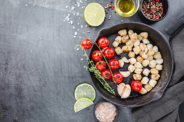 Fried scallops with butter lemon spicy sauce in cast-iron pan