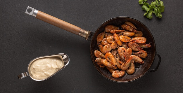 Fried shrimps in a pan with cilantro