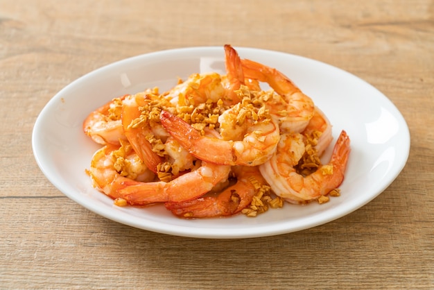 fried shrimps or prawns with garlic on white plate - seafood style