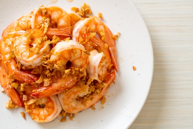 fried shrimps or prawns with garlic on white plate. seafood style