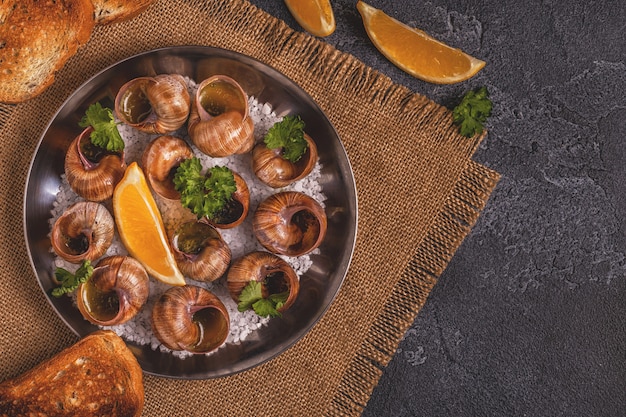 Fried snails with lemon, baguette and parsley