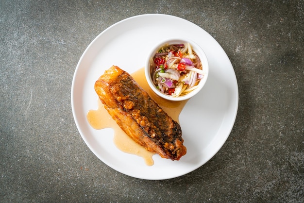 Fried snapper fish with fish sauce and spicy salad