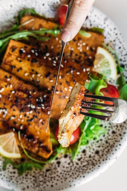 fried tofu in soy sauce with cherry tomatoes, lettuce, lemon and sesame seeds