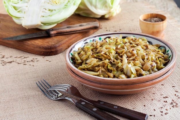 Fried white cabbage with caraway seeds and curry powder on rustic plate