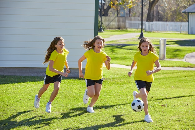 Friend girls teens playing football soccer in a park