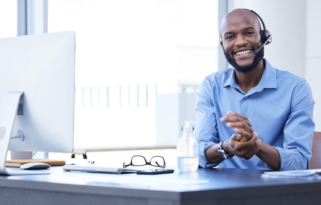 The friendliest call center agent. Shot of a young male call center agent working in an office.