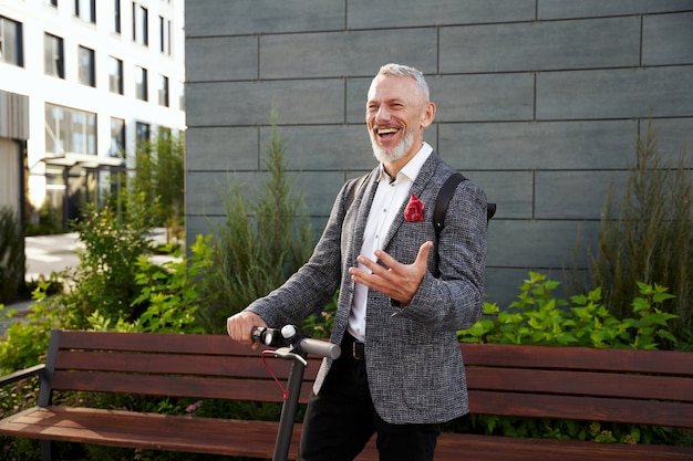 Friendliness cheerful middle aged business man in stylish suit smiling while greeting someone