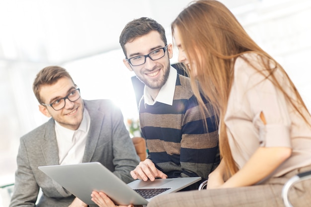 friendly business team working on laptop and discussing business matters.