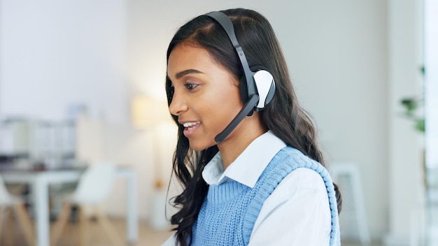 Friendly call center agent using a headset while consulting for customer service and sales support Confident and happy young business woman smiling while operating a helpdesk and talking to clients