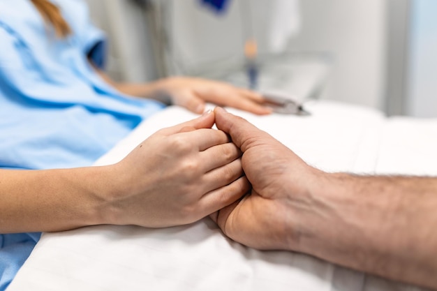 Photo friendly doctor hands holding patient hand support and hope concept male doctors in uniform holding hands with female patients to encourage patient encourage and empathy at nursing hospital ward