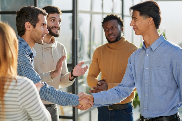 Friendly hr manager or team leader greeting or welcoming new worker