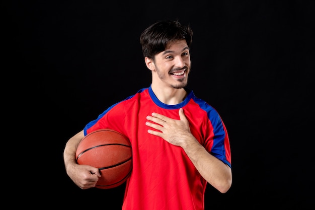 Friendly male player with basketball on black