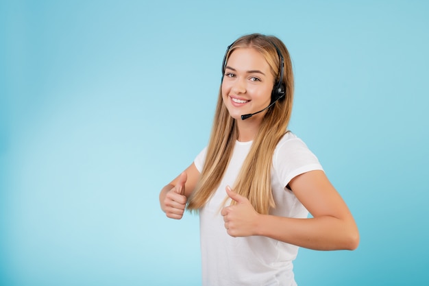 Friendly smiling blonde call center operator with headset isolated over blue