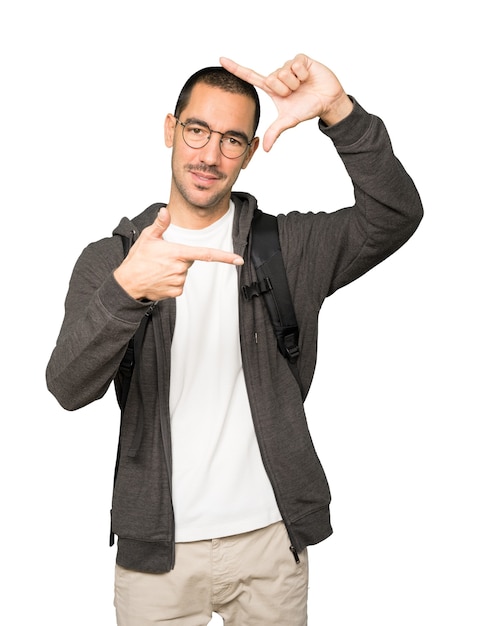 Friendly student making a gesture of taking a photo with the hands