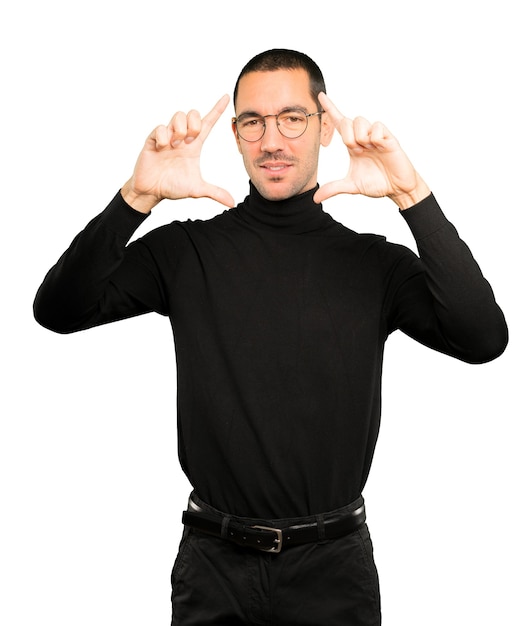 Friendly young man making a gesture of taking a photo with the hands