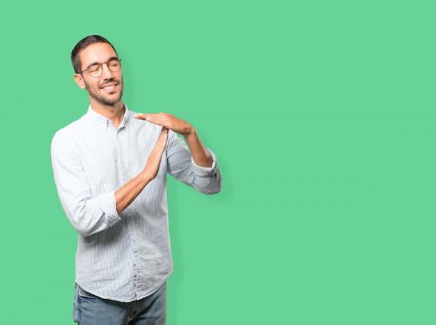 Friendly young man making a time out gesture with his hands