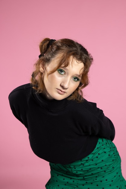 Friendly young woman with a vivacious smile and emotion young redhaired girl on pink background