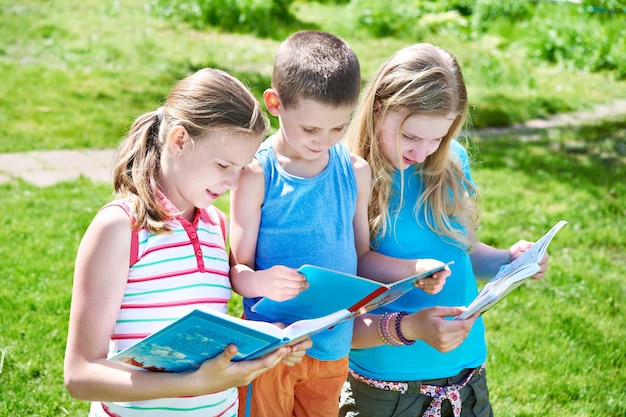 Friends children reading books outdoors