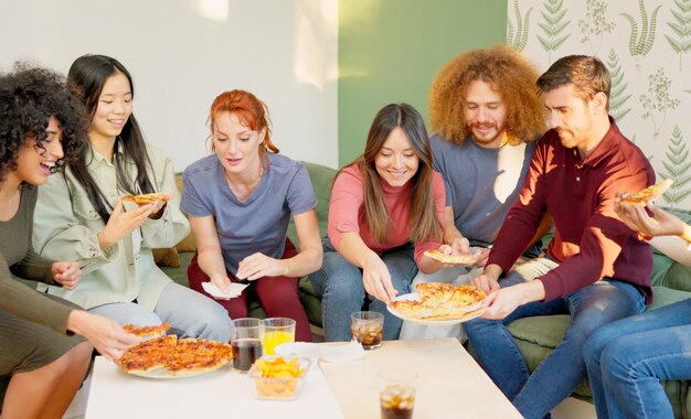 Friends chilling and smiling eating pizza together at home