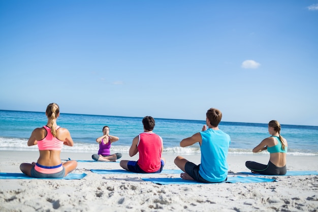 Friends doing yoga together with their teacher 