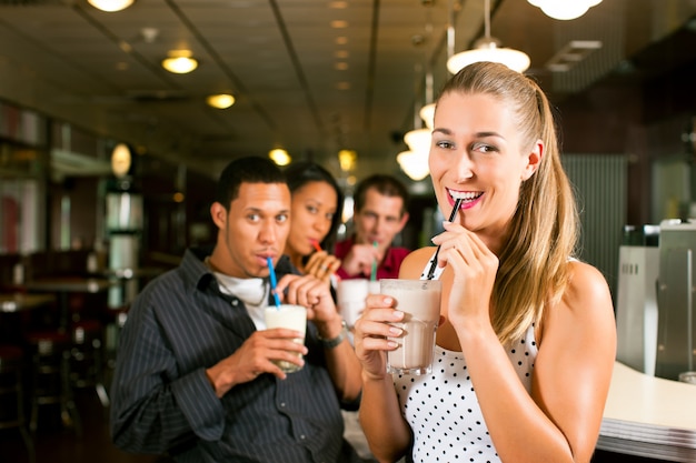 Friends drinking milkshakes in a bar