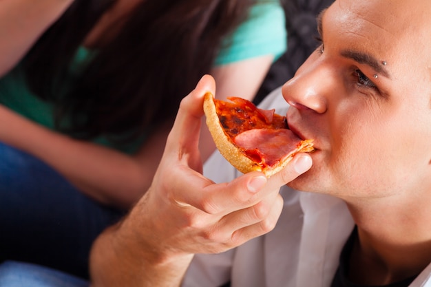 Friends eating pizza at home