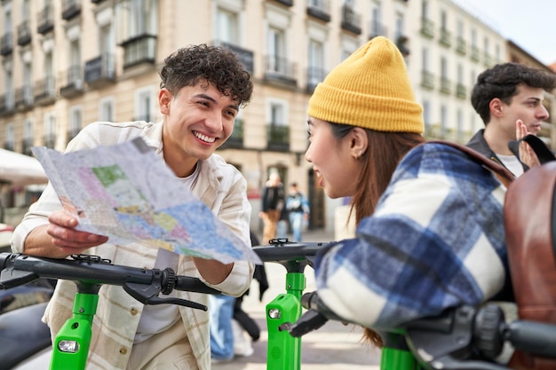 Friends on electric skates check a map before starting their city adventure