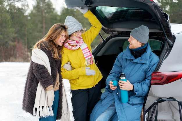 Friends enjoying hot drink while on winter trip