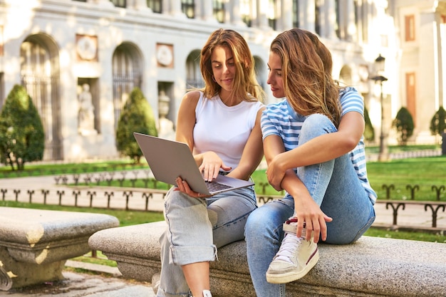 Friends enjoying a laptop in a park