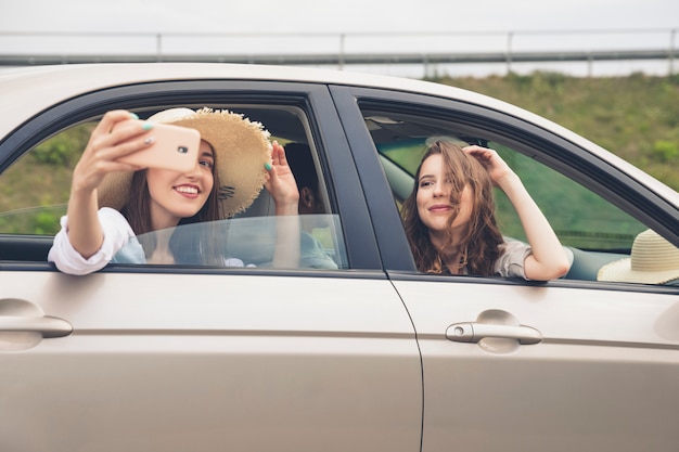 Friends enjoying a road trip and taking selfies