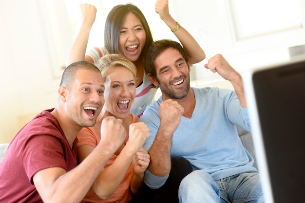 Friends in front of TV watching game