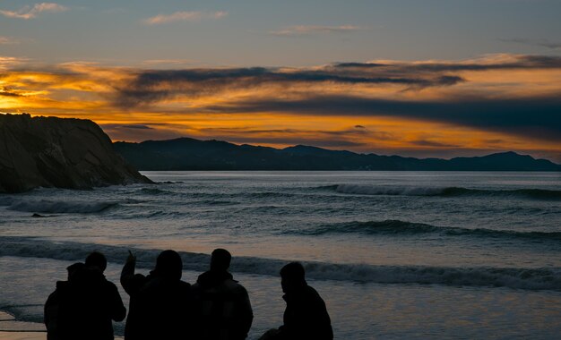 Photo friends gathering at beach to enjoy sunset