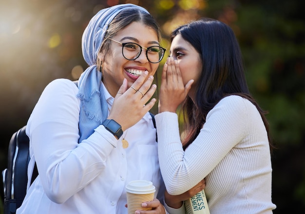 Friends gossip and women talking outdoor and share news with smile surprise an cheerful together Girls female students and young people with happiness whisper in ear and conversation in park