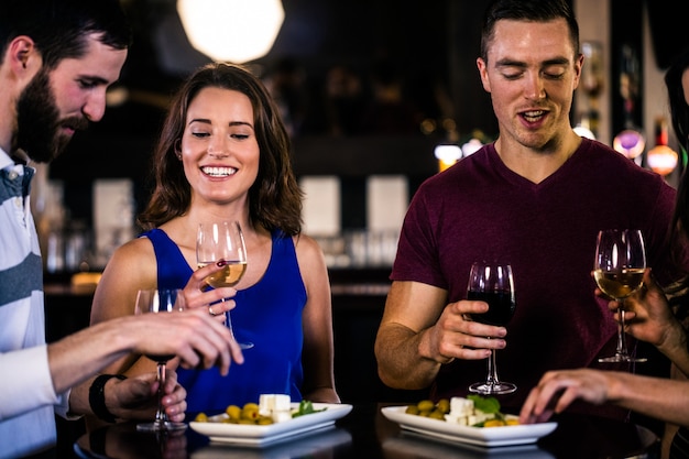 Friends having an aperitif with wine in a bar