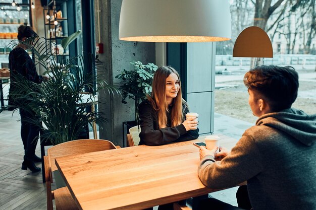 Friends having a chat talking together drinking coffee sitting in a cafe people relaxing in cafe