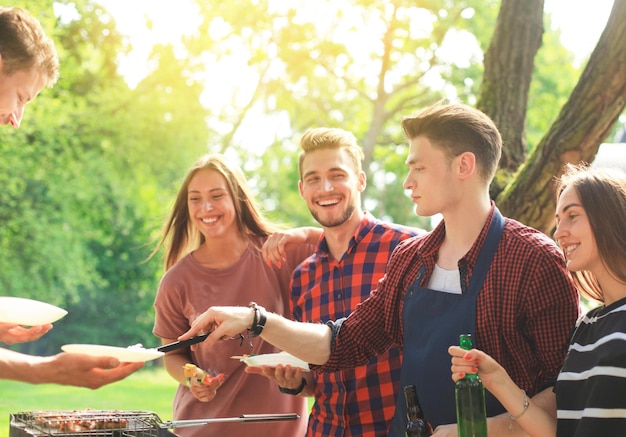 Friends join hand together during at barbecue in nature