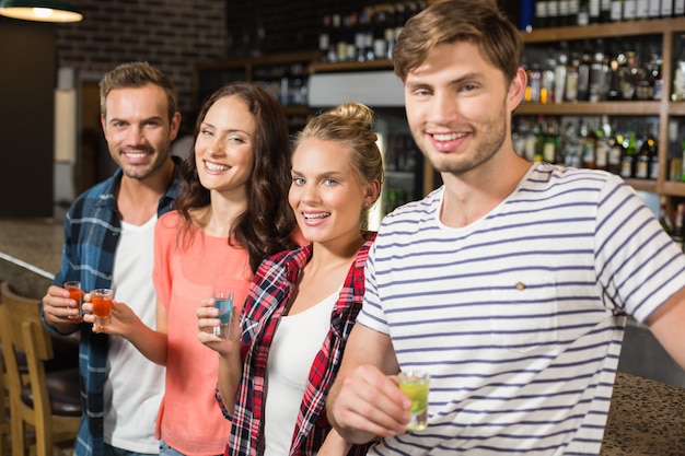 Friends looking at a camera with shots in hand