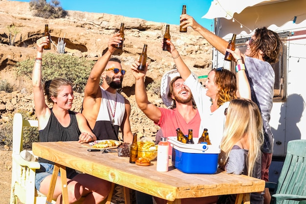 Friends people toasting together with fun in outdoor alternative rural camping site