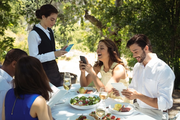 Friends placing order to waiter