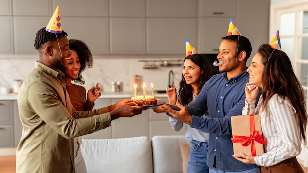 Friends presenting a birthday cake to a woman