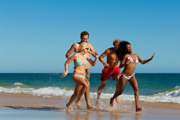 Friends running on beach vacation