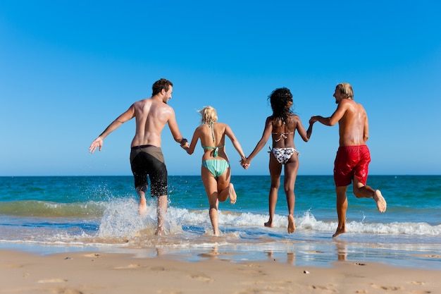 Friends running on beach vacation