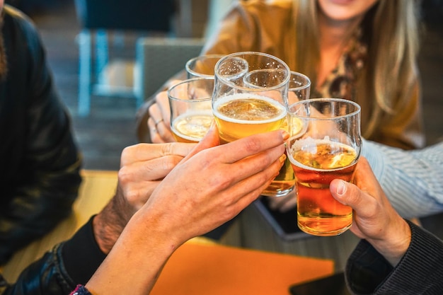 Friends showing hands while holding glasses of beer and cheering with each other Lifestyle concept