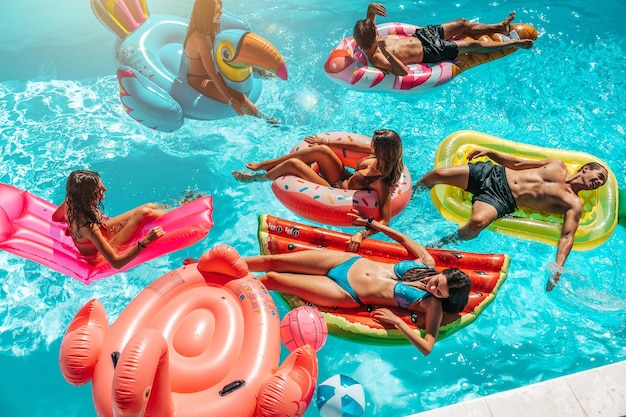 Friends in swimsuit in the pool getting a tan